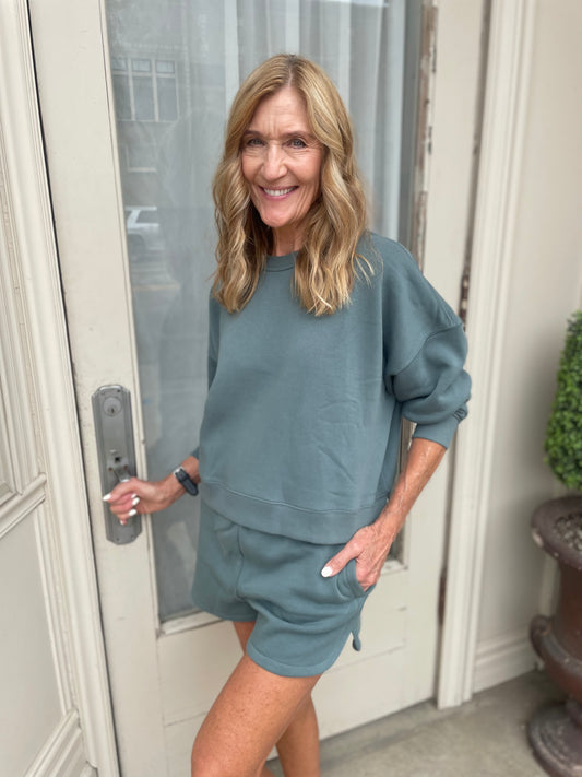 Woman in a blue outfit standing in front of a door