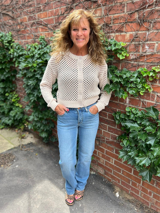 Terri wearing a fishnet button down cardigan with light blue jeans and leopard print sandals